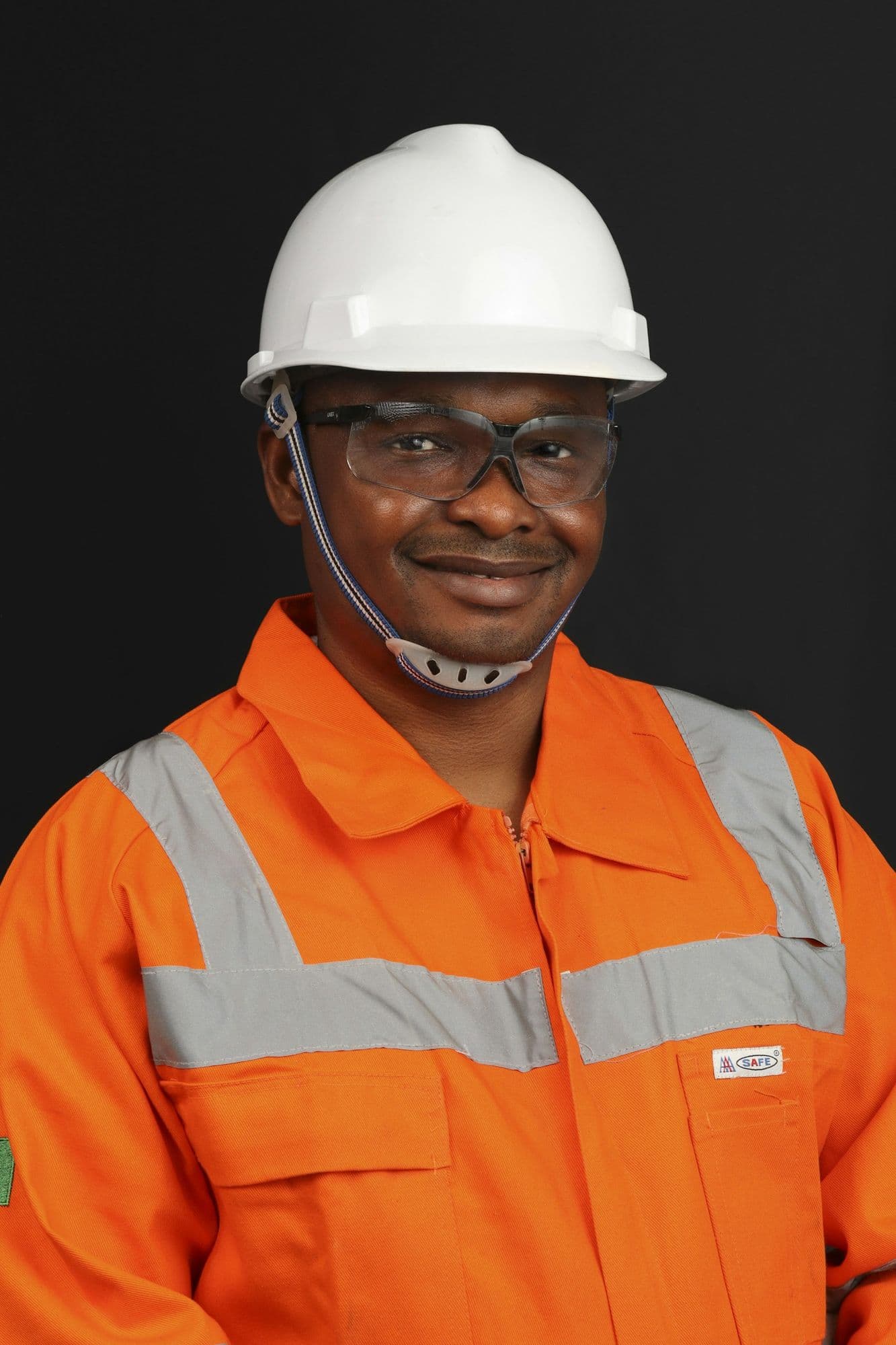 A smiling man in a hard hat and safety jacket