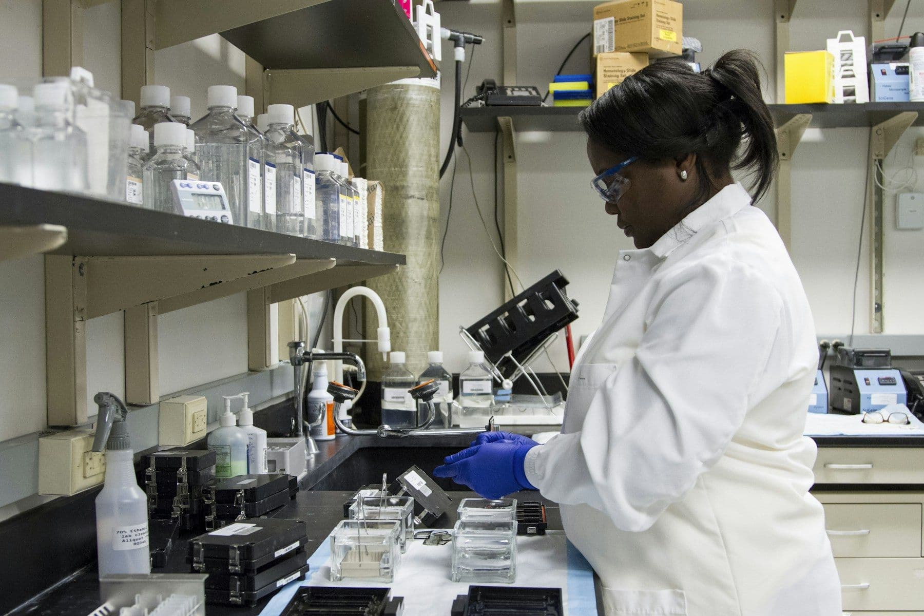 A Black woman scientist working at a laboratory bench
