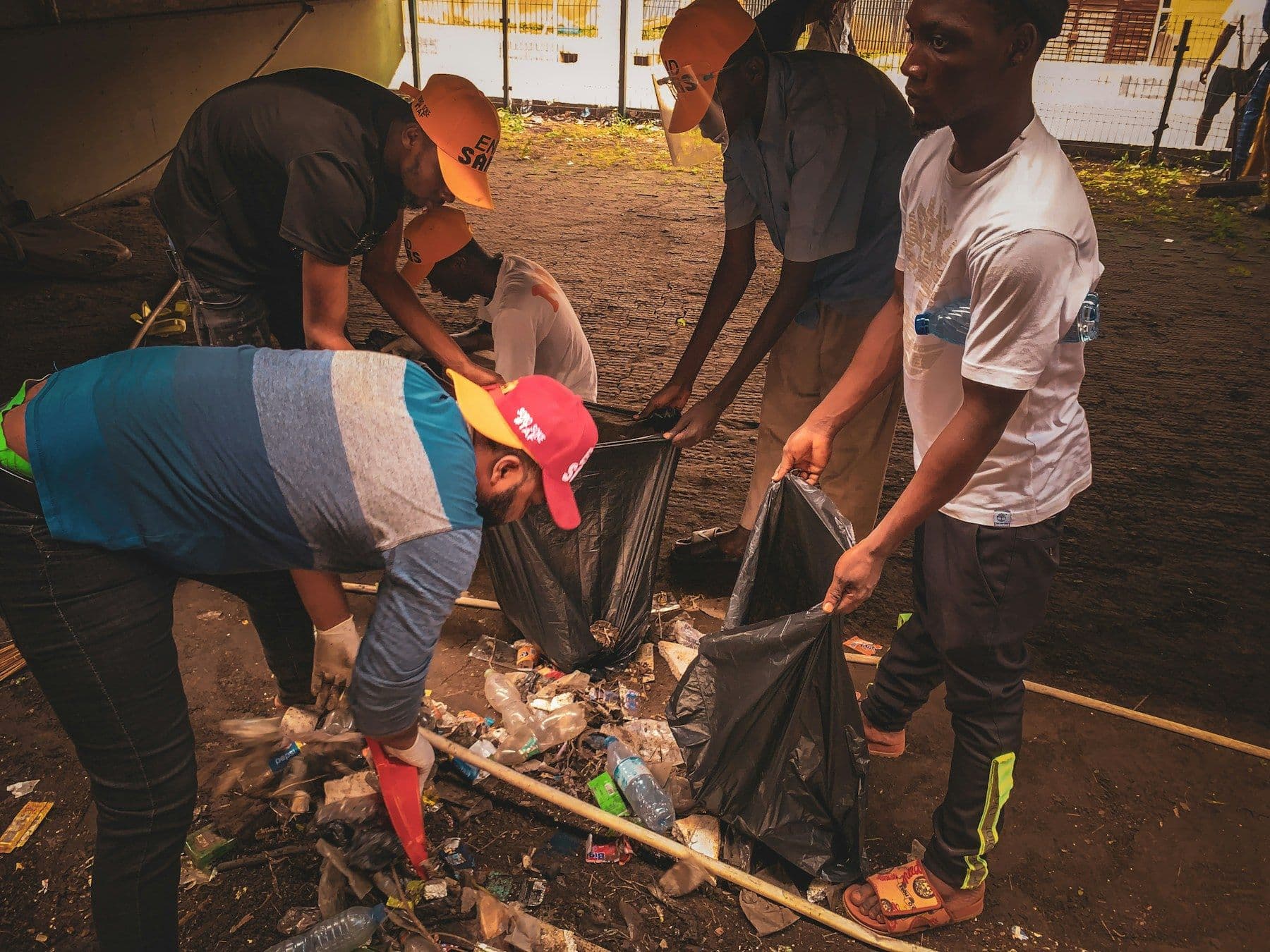 Neighbors in gloves filling trash bags during a cleanup